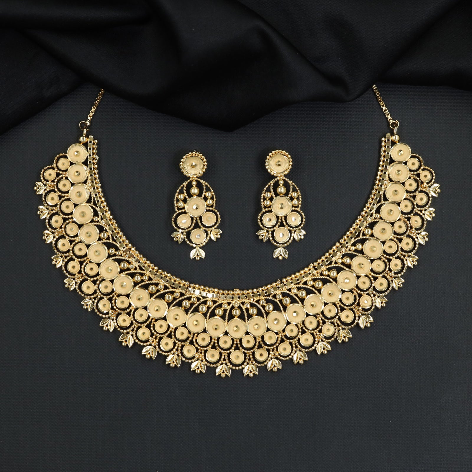Radiant disc clusters sweep across an elegant openwork Forming Necklace