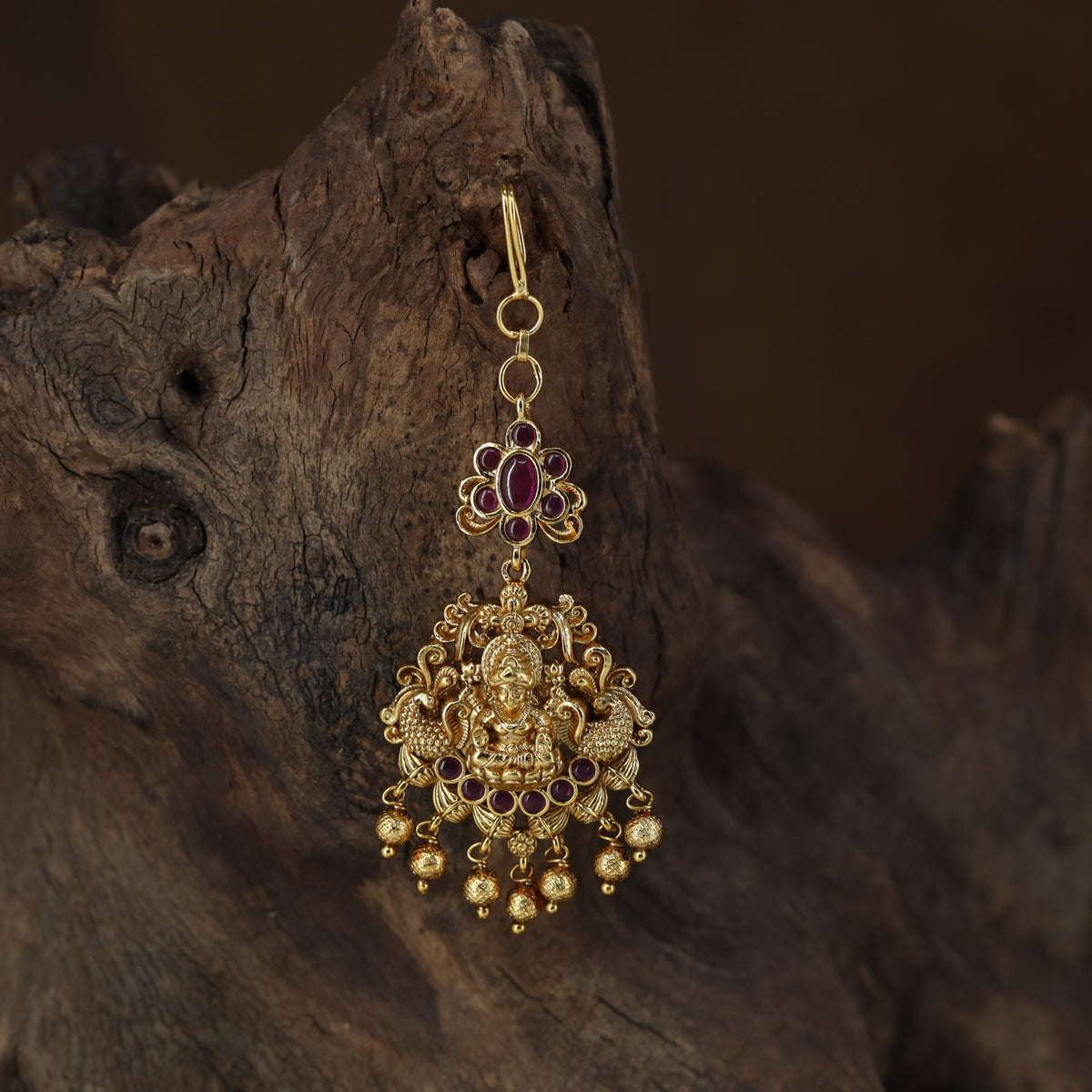 Antique Tikka showcasing a seated Lakshmi framed by graceful peacock figures