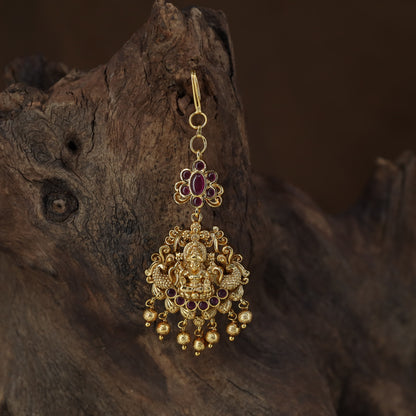 Antique Tikka showcasing a seated Lakshmi framed by graceful peacock figures