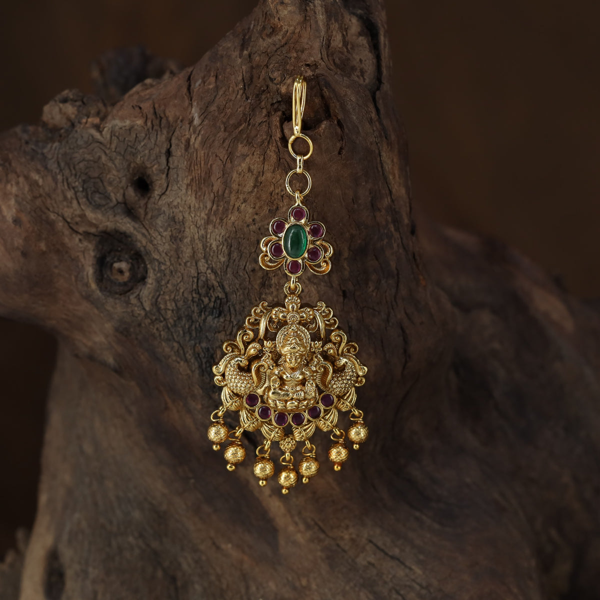 Antique Tikka showcasing a seated Lakshmi framed by graceful peacock figures