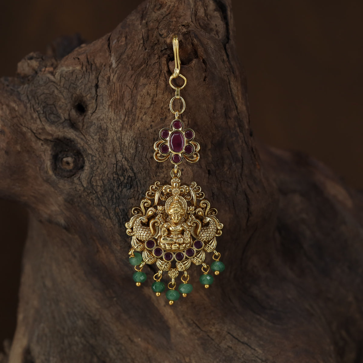 Antique Tikka showcasing a seated Lakshmi framed by graceful peacock figures