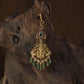 Antique Tikka showcasing a seated Lakshmi framed by graceful peacock figures