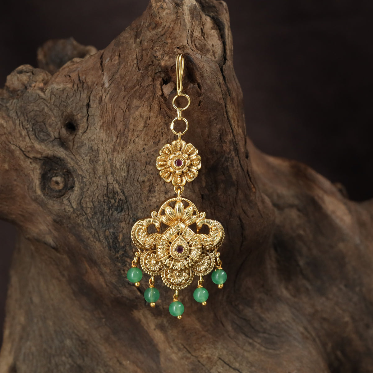 Regal peacock Tikka with ornate floral detailing and graceful hanging drops