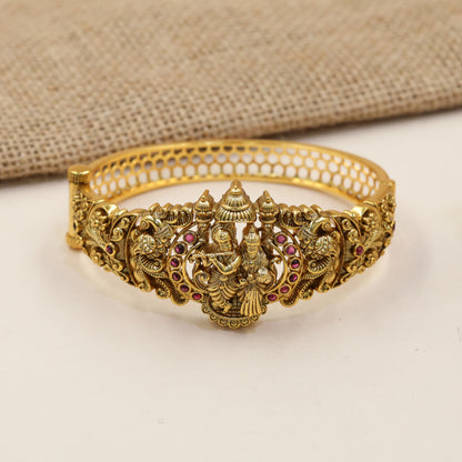 Festive Kada with a sculpted Radhe Krishna centre and detailed temple-style borders