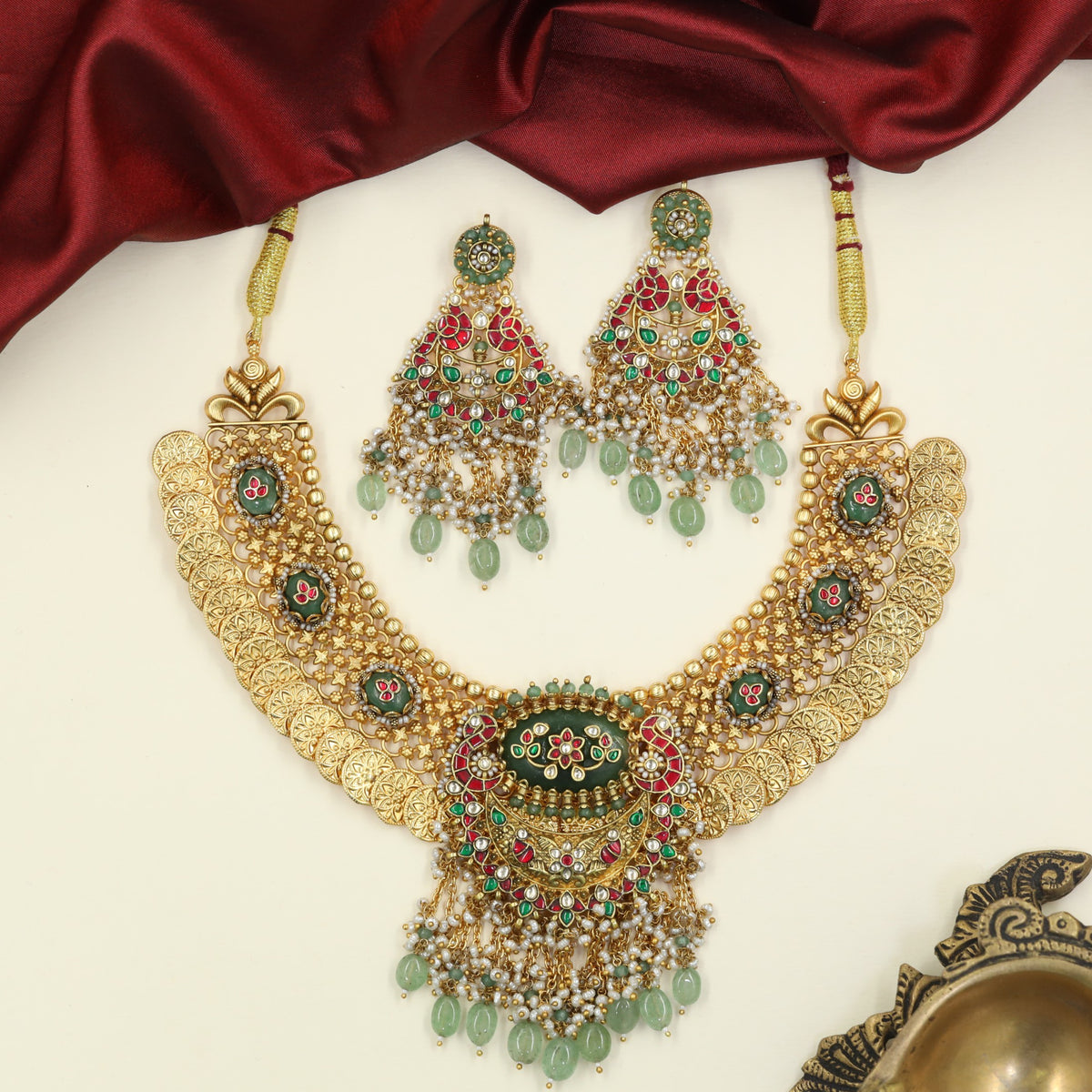 Jadau Necklace enriched by ornamental coin sections and floral accents