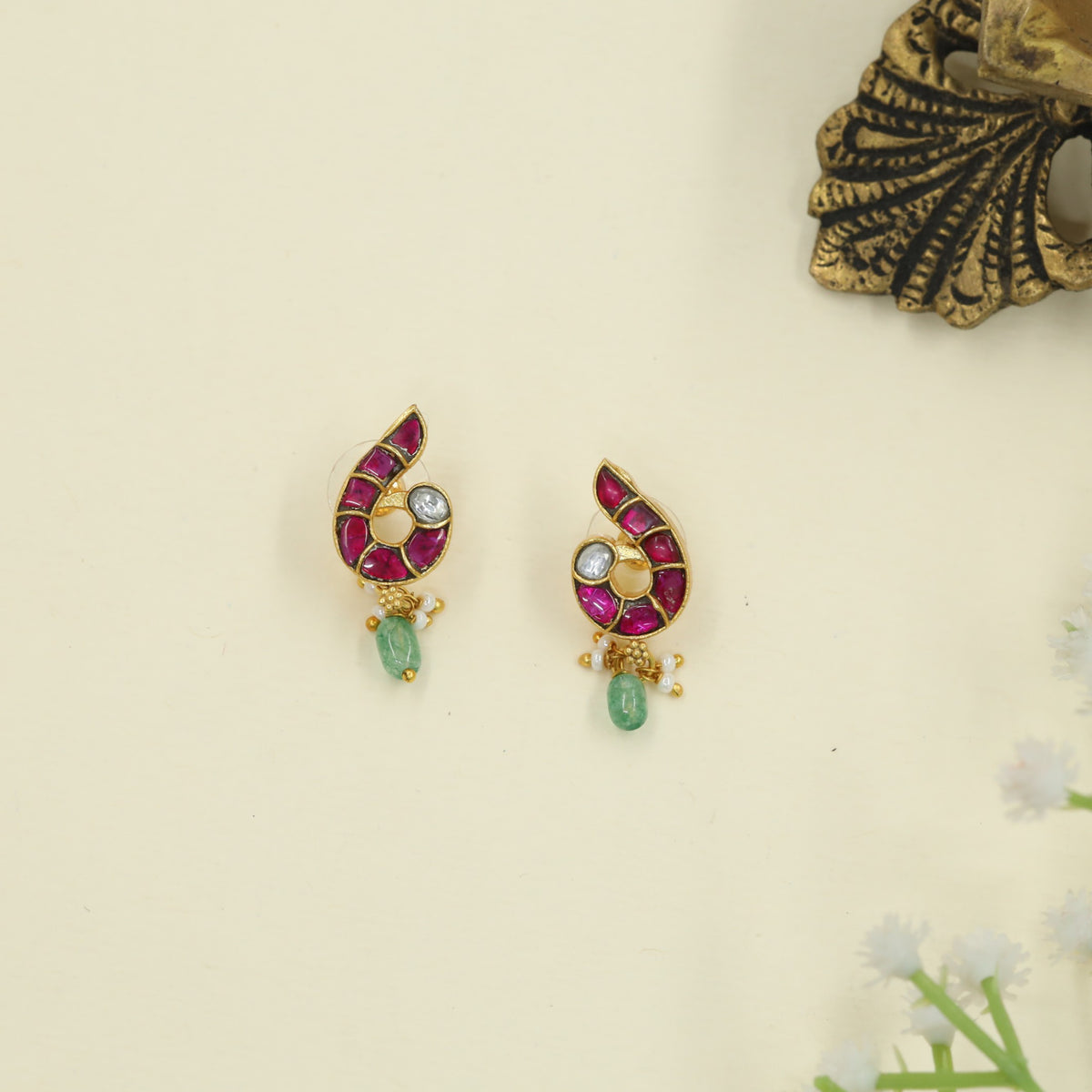 Iconic Jadau peacock studs showcasing gemstone artistry