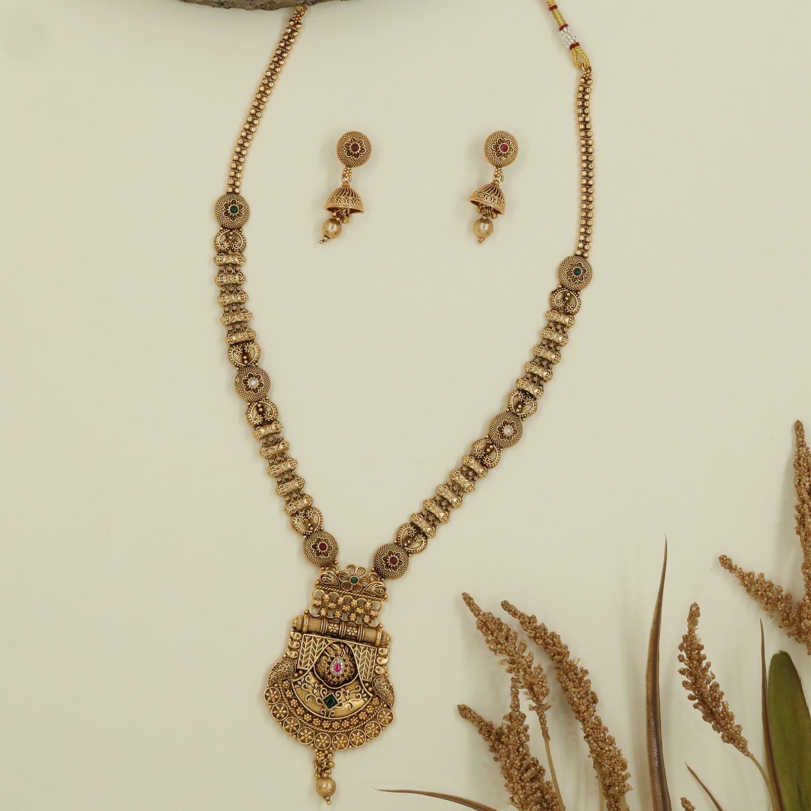 Intricate disc long haara with embossed links and wide drop pendant with central accent