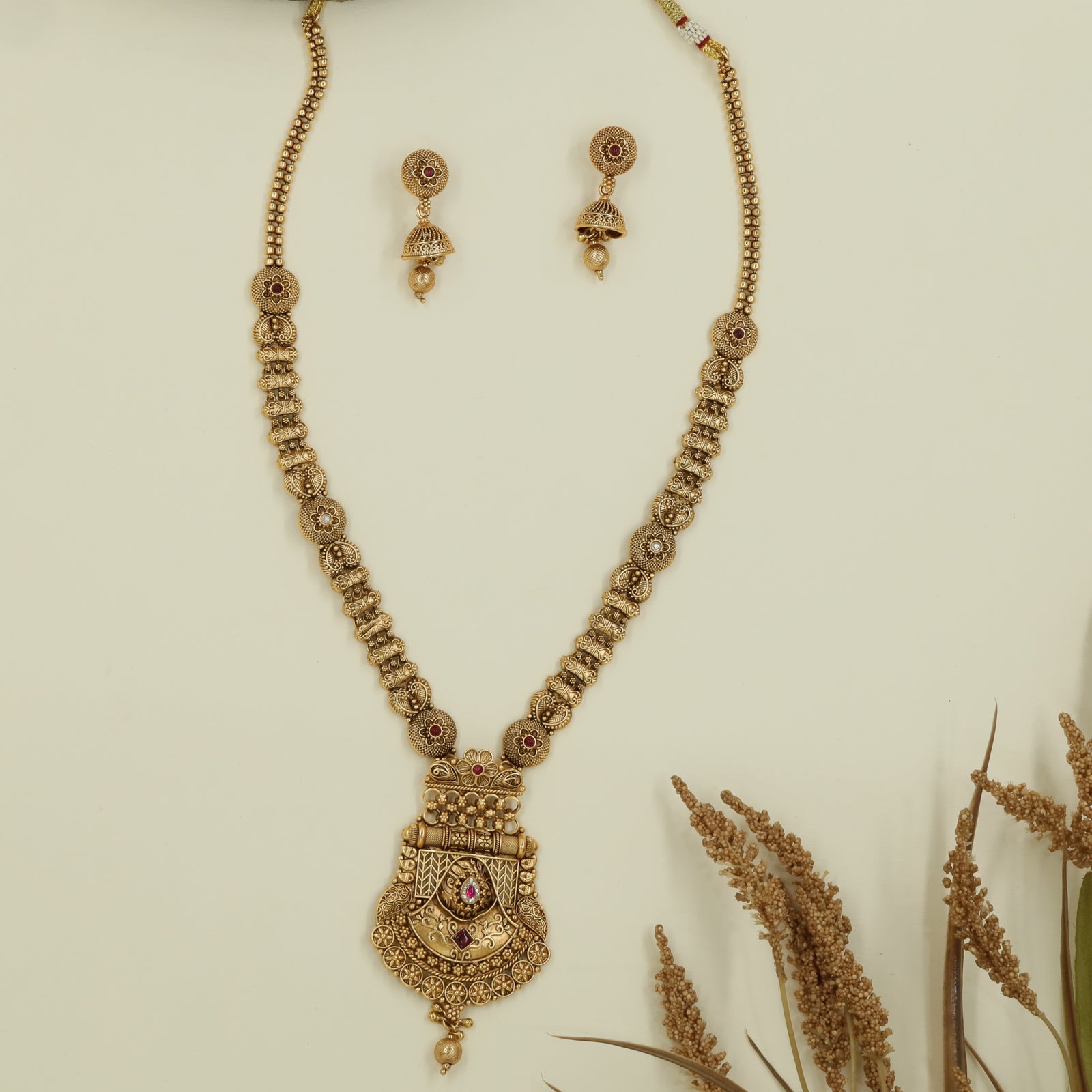 Intricate disc long haara with embossed links and wide drop pendant with central accent
