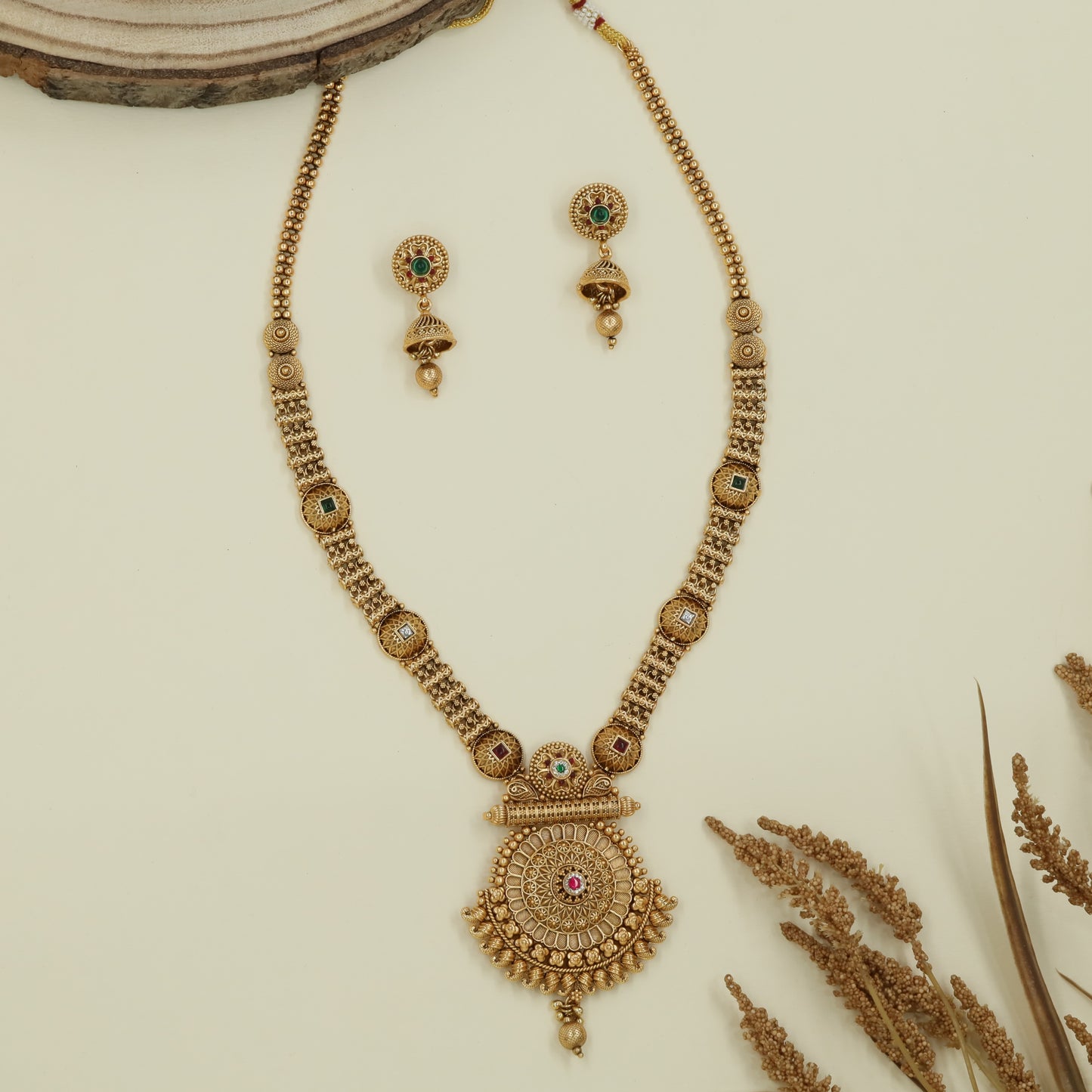 Embossed disc long haara with carved round connectors and layered circular pendant with drop