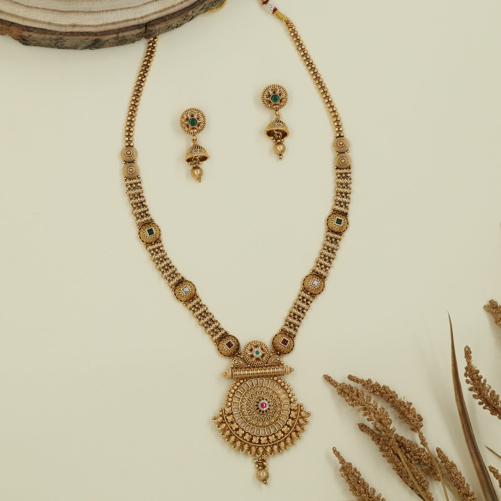 Embossed disc long haara with carved round connectors and layered circular pendant with drop