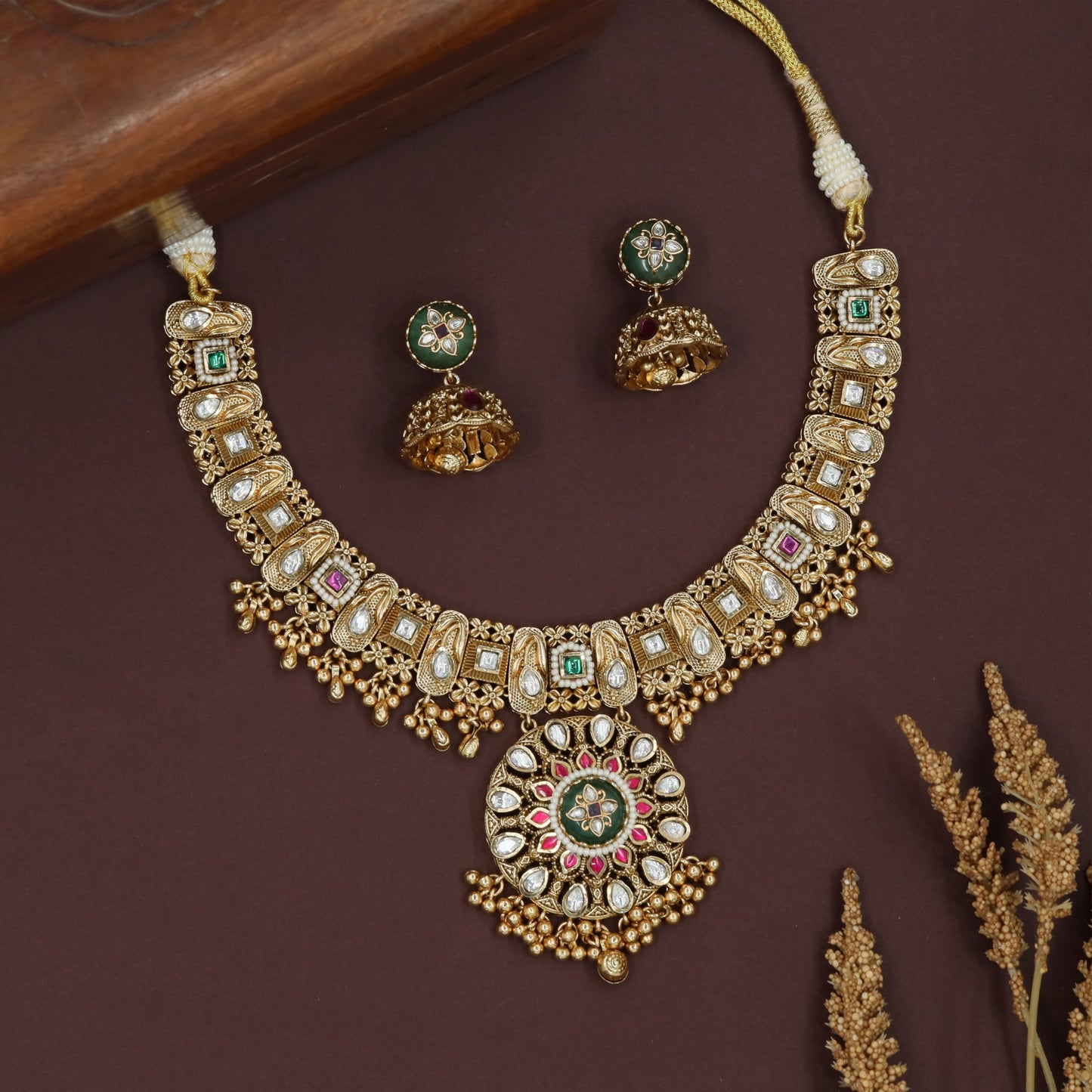 Curved panel kundan necklace with oval frames and central round pendant cluster