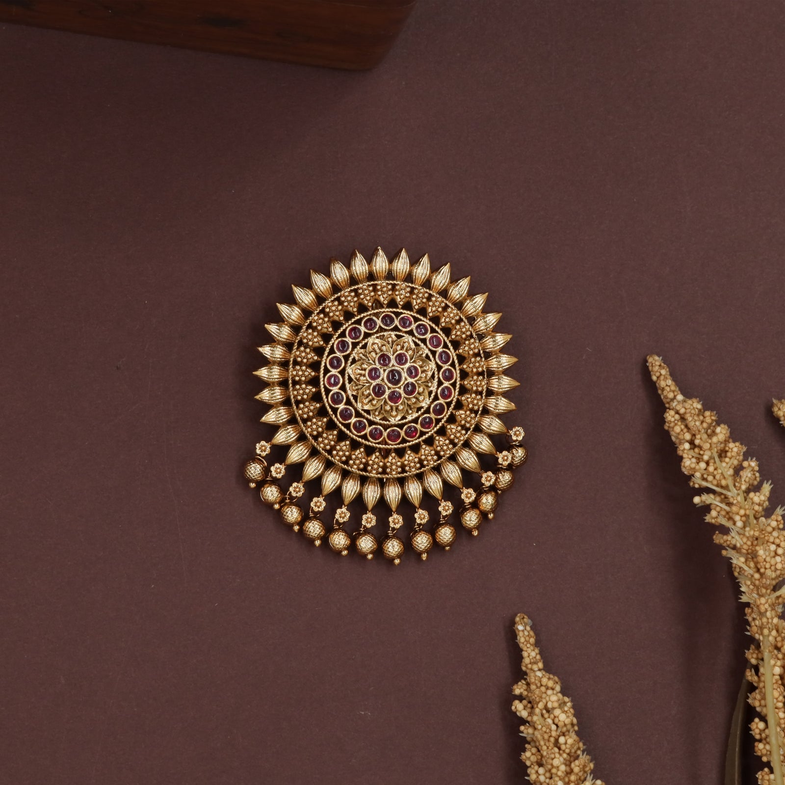 Sunburst round jade bille with petal edged frame and hanging bead clusters