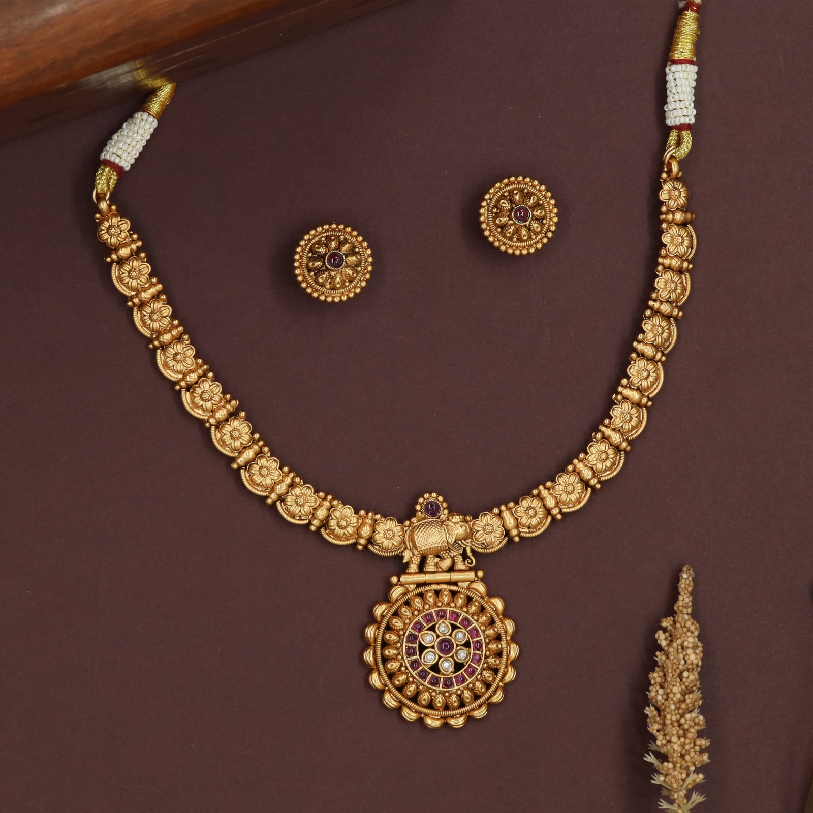 Floral link kundan necklace with carved flower panels and central elephant pendant