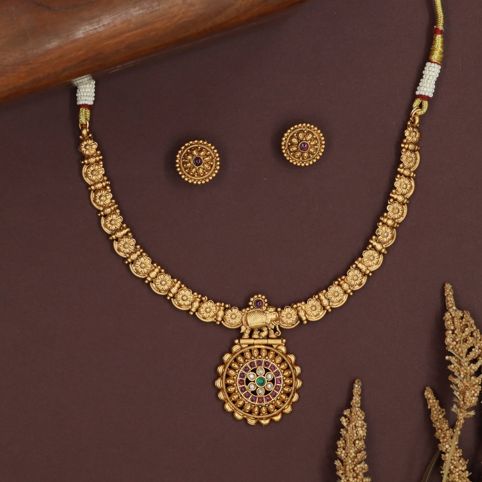 Floral link kundan necklace with carved flower panels and central elephant pendant