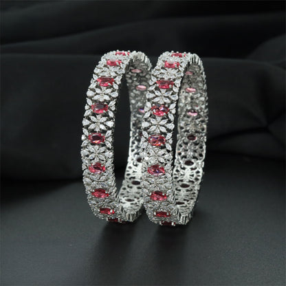 Rhodium bangles featuring framed oval elements and clustered stonework